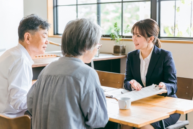 若い営業と話す中高年夫婦