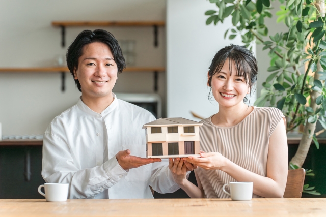 家の模型をもつ夫婦