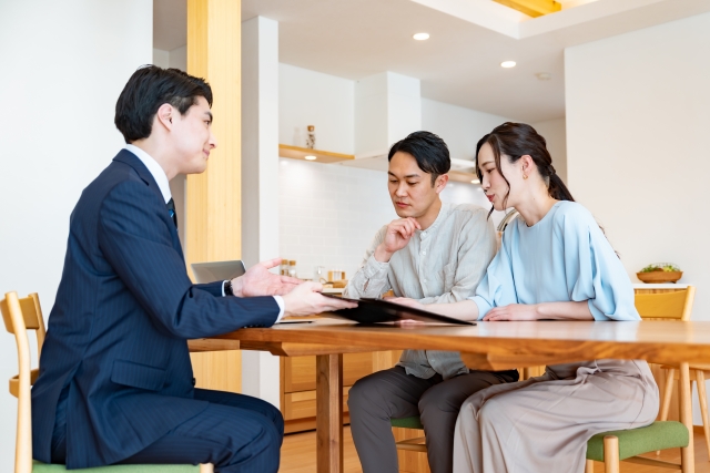 リビングで不動産営業マンと話す夫婦