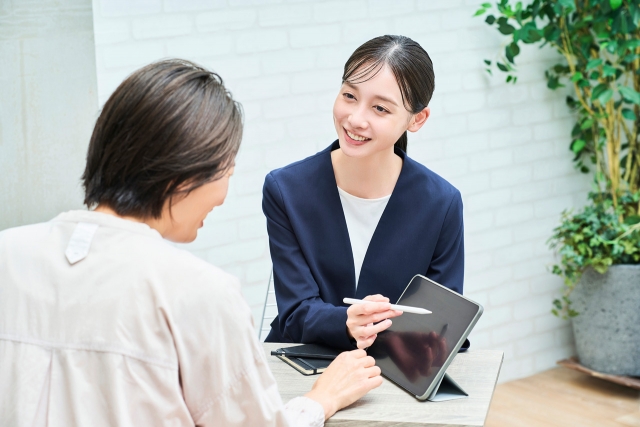 女性に説明するスーツ姿の女性